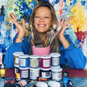 Caroline Faindt artiste peintre contemporaine parisienne devant ses pots de peinture dans son atelier
